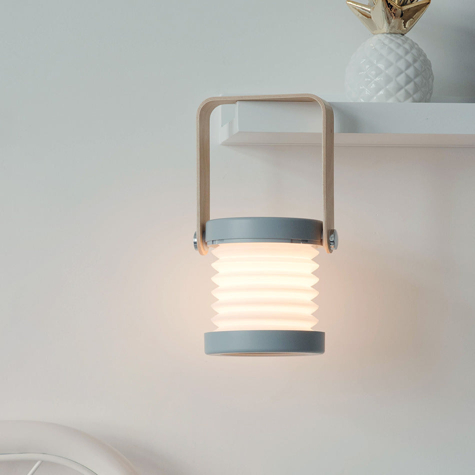 Lykt Lanta LED lantern in Urban Ash, featuring a unique grey expandable shade, matching grey base, and a natural wooden handle, perfect for modern home decor.